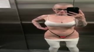 The busty blonde woman stepped into the crowded elevator, her massive tits bouncing with every step